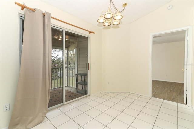 empty room featuring an inviting chandelier and tile patterned flooring