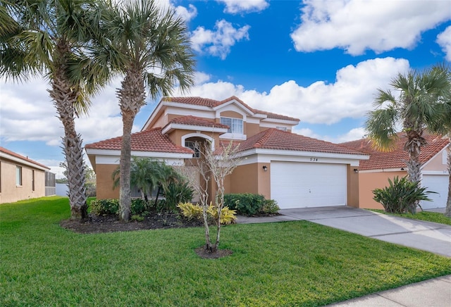 mediterranean / spanish-style house with a front yard, driveway, an attached garage, stucco siding, and a tiled roof