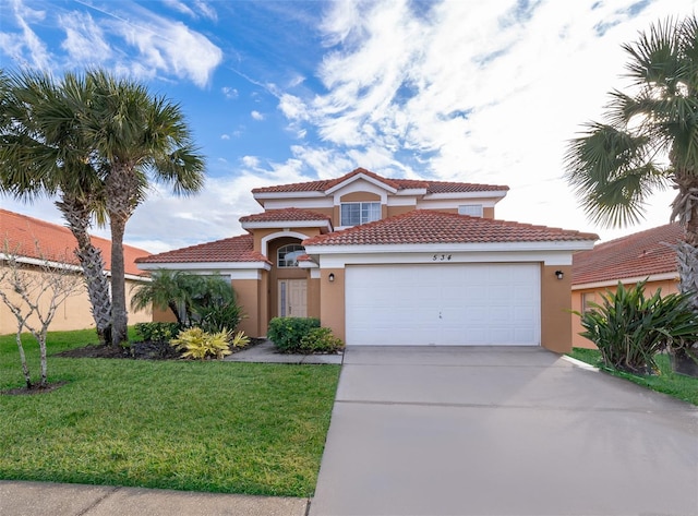 mediterranean / spanish house with stucco siding, driveway, a front yard, and a garage