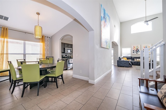 dining space with visible vents, arched walkways, a healthy amount of sunlight, and ceiling fan