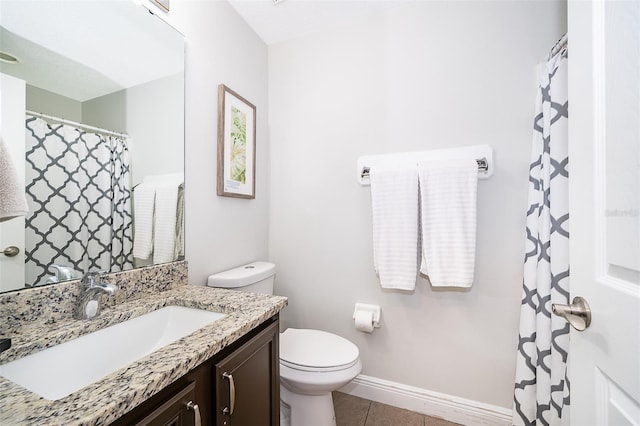 bathroom featuring vanity, toilet, baseboards, and tile patterned flooring