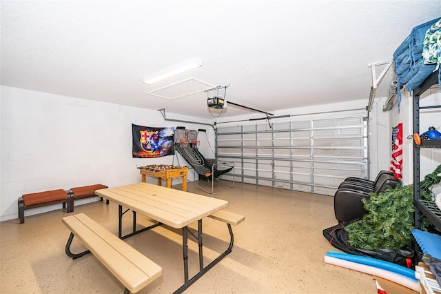 garage featuring concrete block wall and a garage door opener