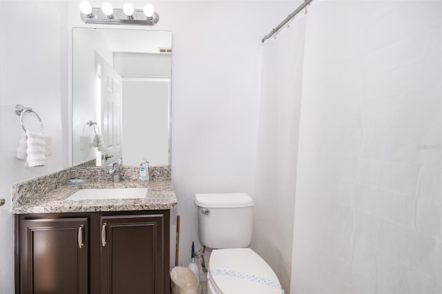 bathroom with visible vents, toilet, and vanity