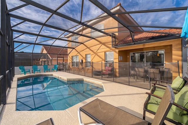 view of pool featuring glass enclosure, a patio, and a fenced in pool