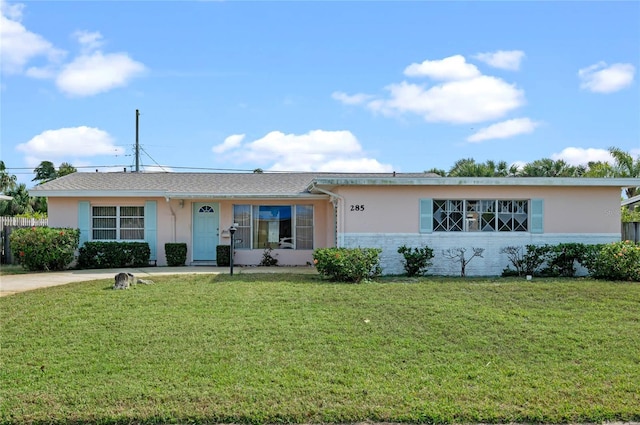 ranch-style house with a front lawn and stucco siding