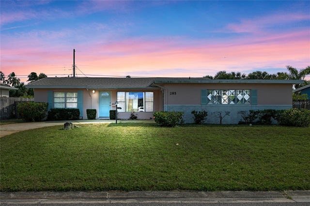 single story home with stucco siding, a front yard, and fence