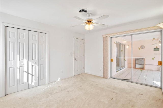 unfurnished bedroom featuring heating unit, visible vents, carpet floors, and ceiling fan