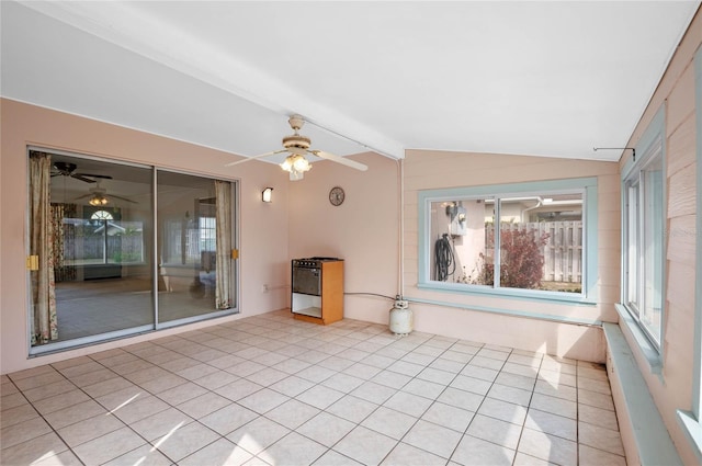 empty room featuring light tile patterned floors, ceiling fan, and vaulted ceiling with beams