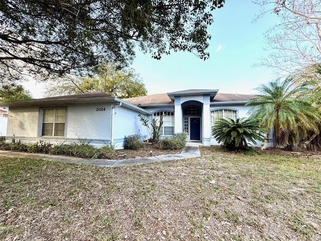 view of front facade with a front lawn and stucco siding