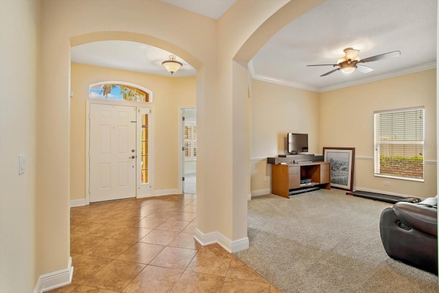 entrance foyer with a wealth of natural light, tile patterned flooring, arched walkways, and carpet