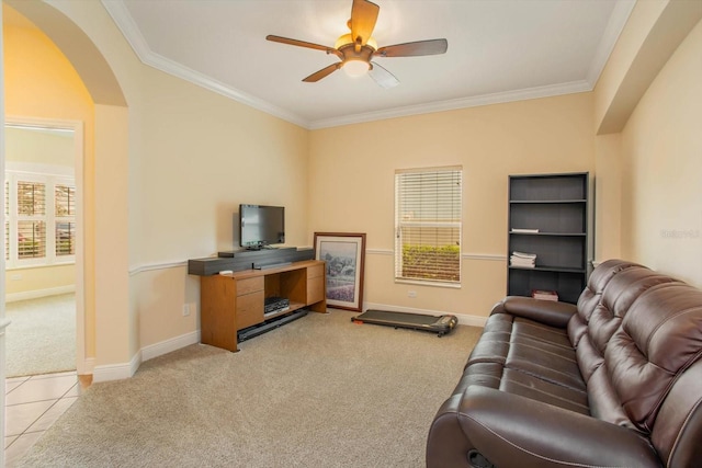 living room with arched walkways, carpet floors, ornamental molding, and baseboards