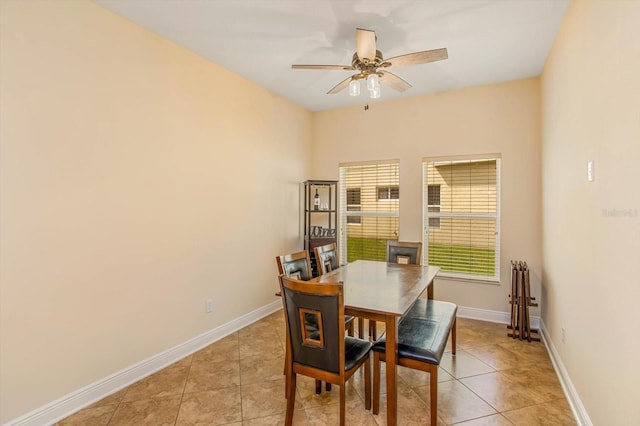 dining space with light tile patterned flooring, ceiling fan, and baseboards