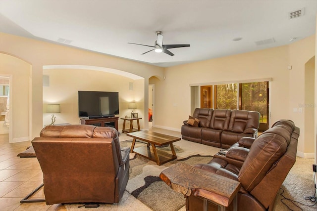 living room with plenty of natural light, light tile patterned floors, visible vents, and arched walkways