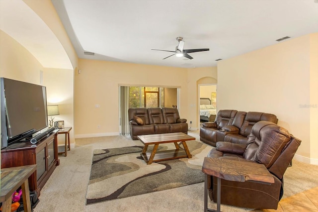 living area featuring visible vents, arched walkways, ceiling fan, and baseboards