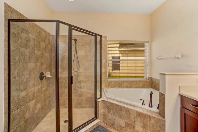 bathroom with a stall shower, a garden tub, and vanity