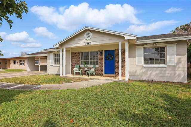 ranch-style home featuring brick siding, covered porch, and a front lawn