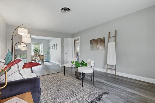 living room with visible vents, baseboards, and wood finished floors