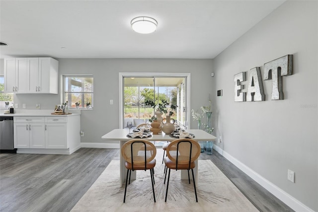 dining area with visible vents, light wood-style flooring, and baseboards