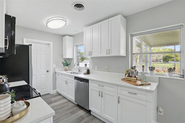 kitchen featuring a sink, visible vents, white cabinetry, and stainless steel appliances