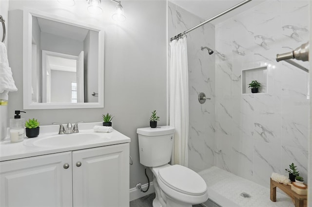 full bath featuring vanity, toilet, baseboards, and a stall shower