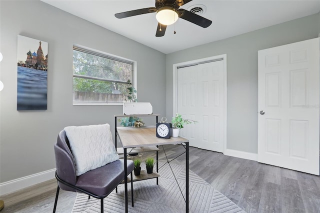 office featuring a ceiling fan, visible vents, wood finished floors, and baseboards