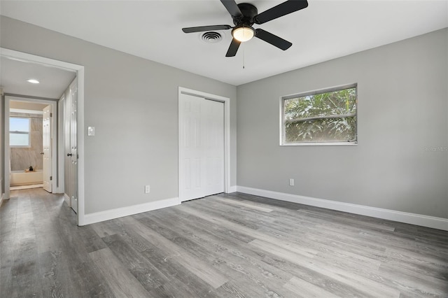 unfurnished bedroom featuring visible vents, a ceiling fan, wood finished floors, a closet, and baseboards