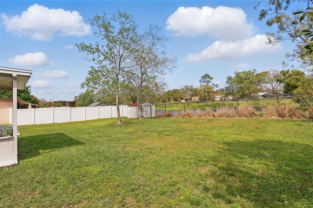 view of yard featuring an outbuilding, a storage shed, and fence