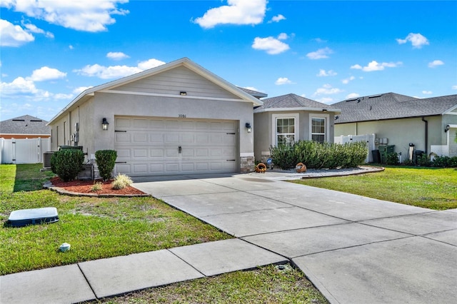 ranch-style home with a garage, stucco siding, fence, and a front yard