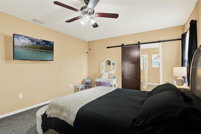 carpeted bedroom with ceiling fan, a barn door, visible vents, and baseboards