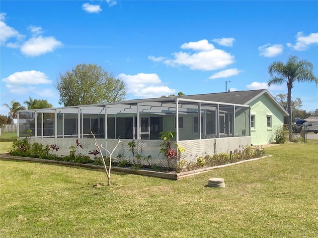 back of property with glass enclosure and a lawn