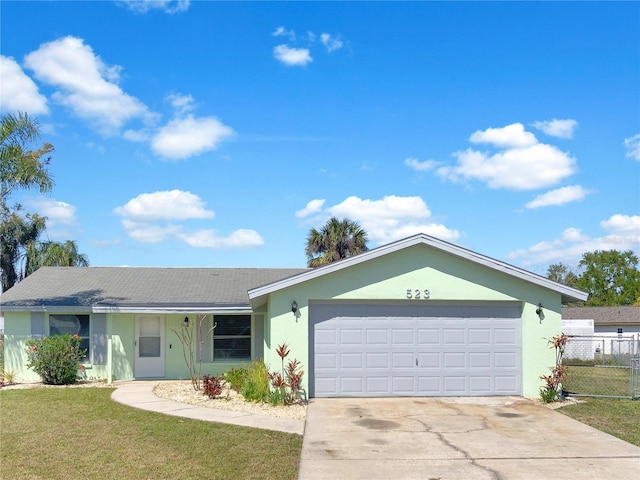 ranch-style house with a garage, driveway, fence, a front yard, and stucco siding