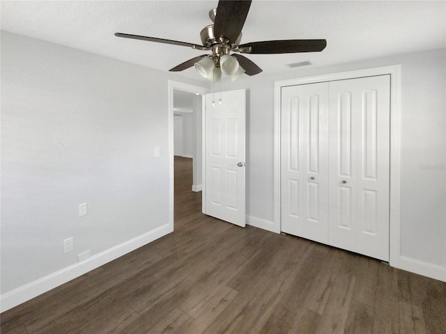 unfurnished bedroom featuring a closet, visible vents, ceiling fan, wood finished floors, and baseboards