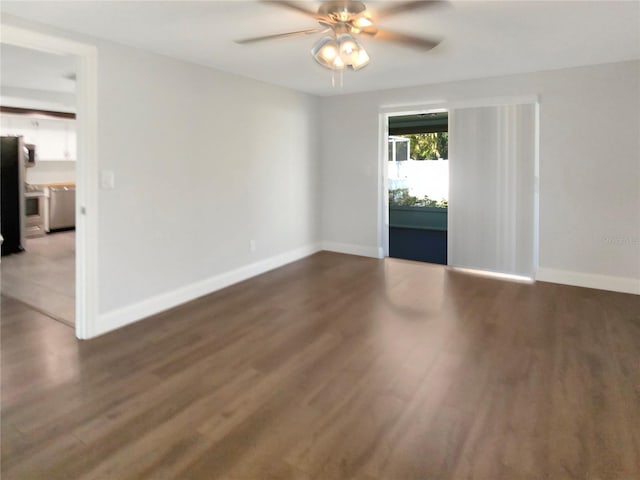 unfurnished room with a ceiling fan, baseboards, and wood finished floors