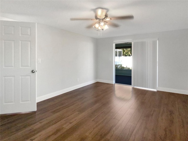 spare room featuring dark wood finished floors, a ceiling fan, and baseboards