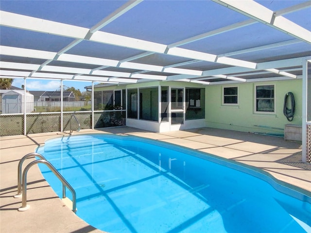 view of swimming pool featuring a patio area, fence, glass enclosure, and a fenced in pool