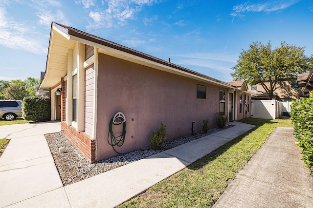 view of property exterior featuring a garage, concrete driveway, fence, and stucco siding