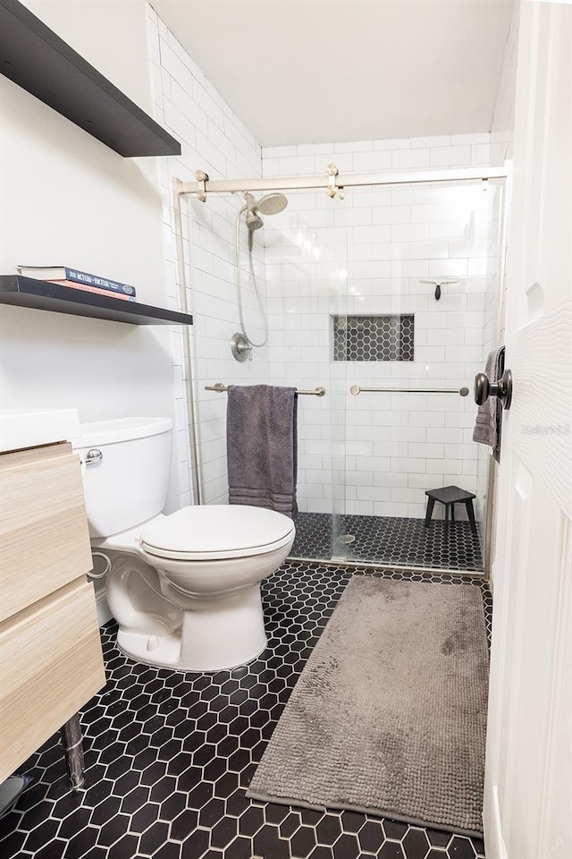 full bath with a stall shower, vanity, and toilet