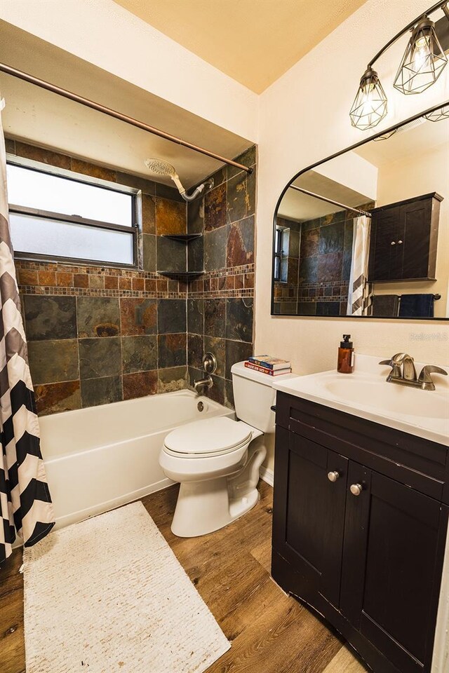 full bathroom with toilet, shower / tub combo, wood finished floors, and vanity