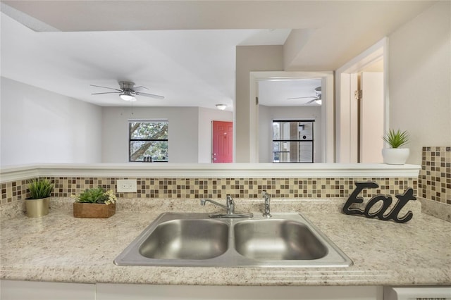 kitchen with a sink, backsplash, and ceiling fan