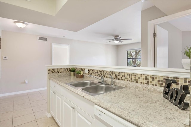 kitchen featuring light tile patterned floors, a sink, visible vents, baseboards, and tasteful backsplash