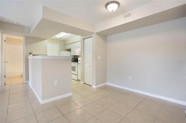 kitchen with light tile patterned floors, visible vents, white cabinets, baseboards, and electric stove