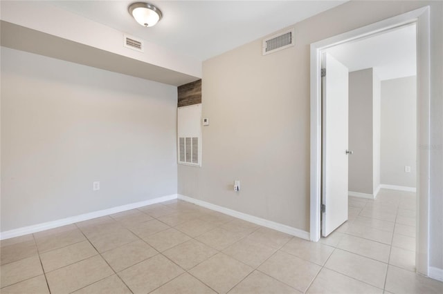 unfurnished room with light tile patterned flooring, visible vents, and baseboards