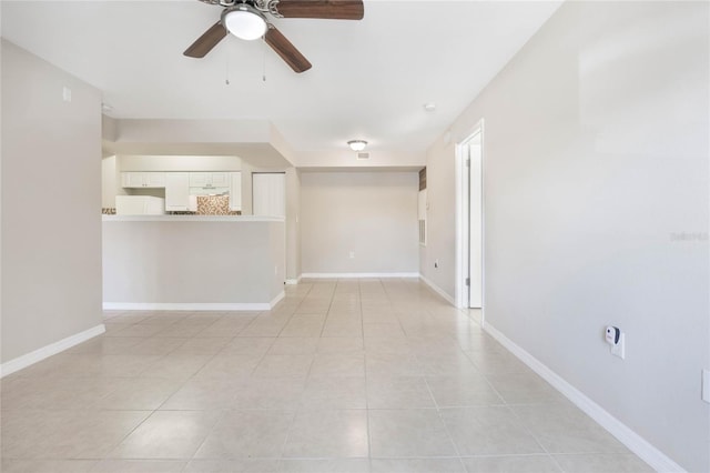 spare room with ceiling fan, baseboards, and light tile patterned flooring