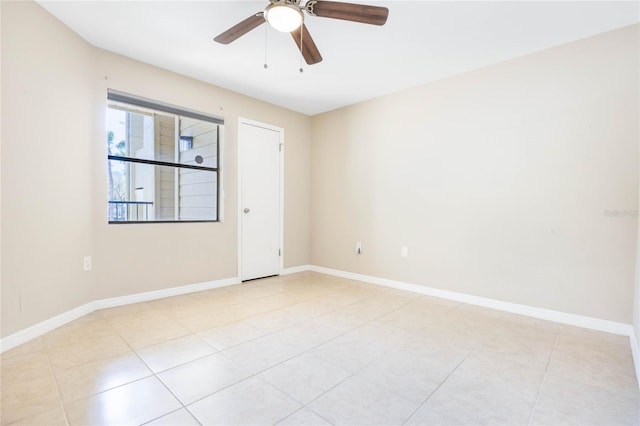 empty room featuring light tile patterned floors, baseboards, and a ceiling fan