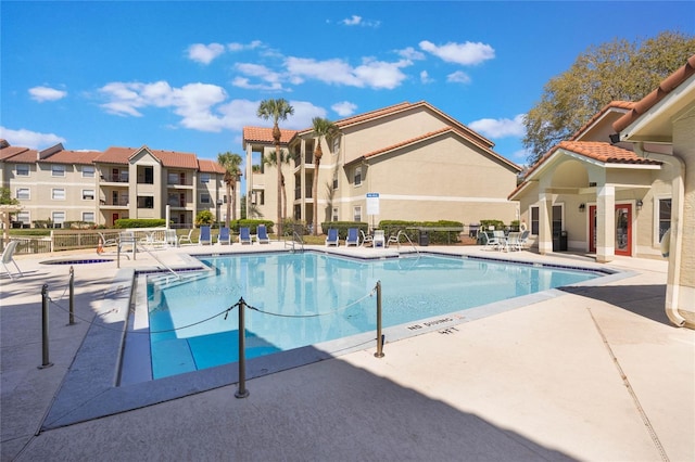 pool with a patio and fence