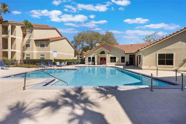 community pool featuring a patio area and fence