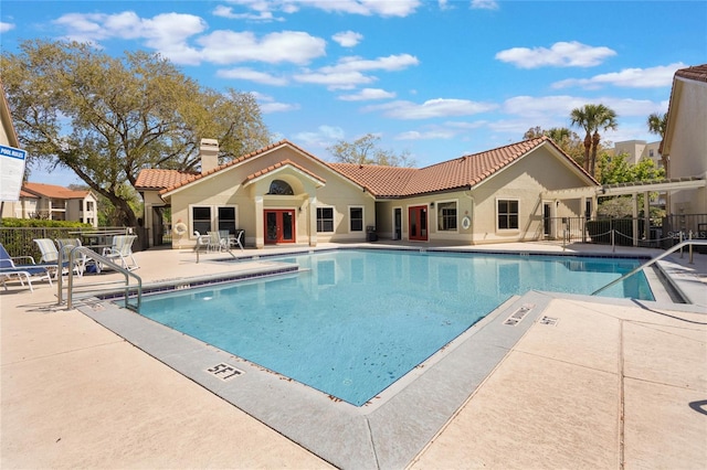 pool with a patio area and fence