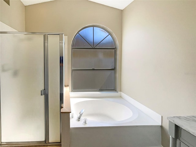 bathroom featuring a stall shower, a garden tub, and vanity