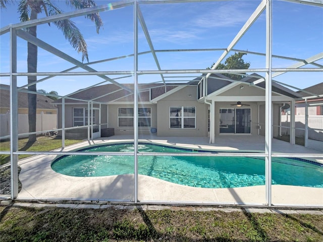 view of swimming pool featuring a patio, a lanai, a ceiling fan, and fence