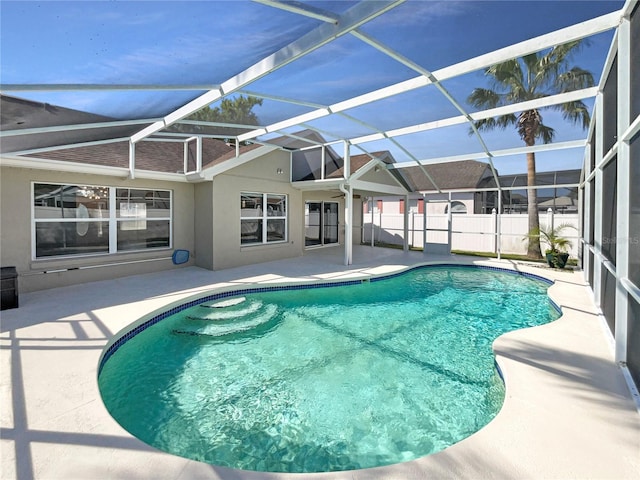 view of pool featuring glass enclosure, a patio area, fence, and a fenced in pool